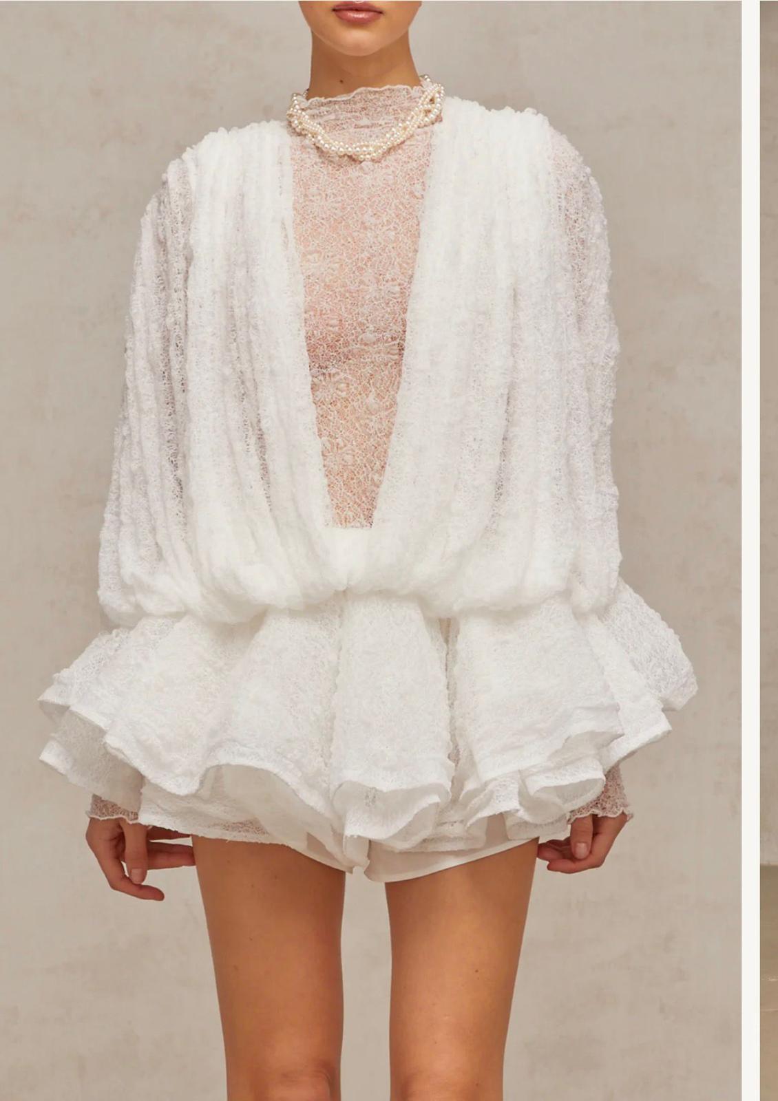 White textured lace blouson with plunge drape and ruffled peplum hem by AKUVEE
